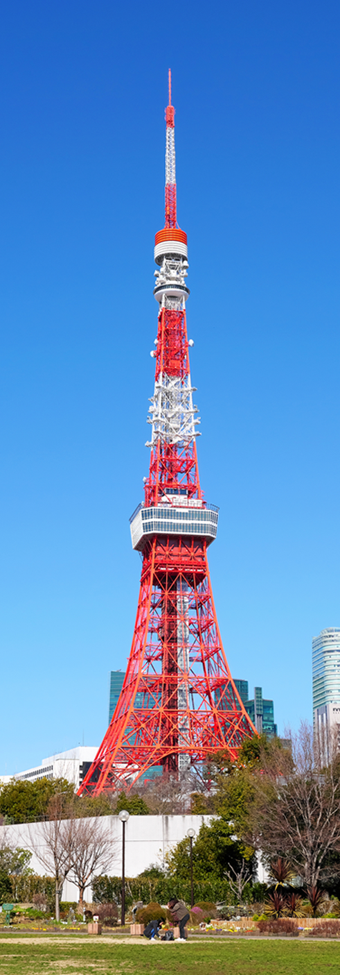 Tokyo Tower rising against a blue sky, seen from Shiba Park