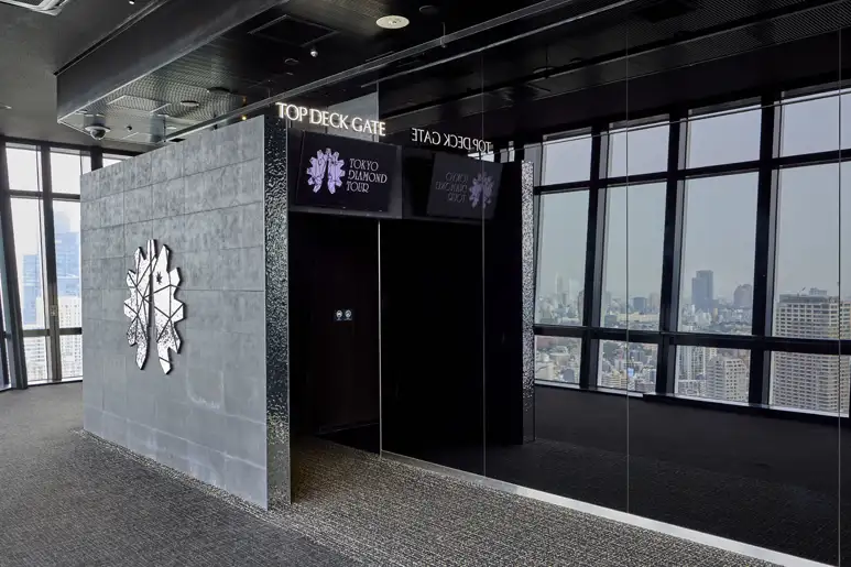 TOP DECK TOURの専用入口「TOP DECK GATE」と、窓の外に広がる東京の街並み